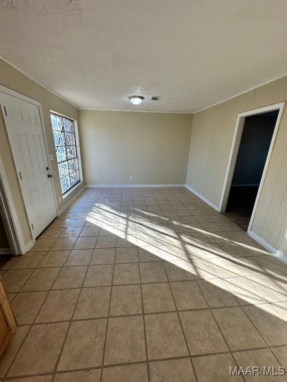 interior space featuring light tile patterned flooring and a textured ceiling