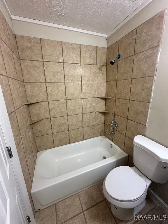 bathroom with toilet, tiled shower / bath combo, tile patterned flooring, and a textured ceiling