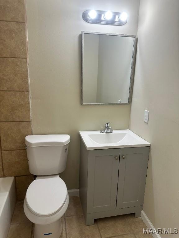 bathroom with toilet, vanity, and tile patterned floors