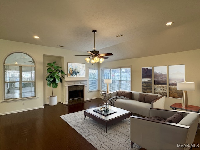 living room featuring ceiling fan, vaulted ceiling, and dark wood-type flooring