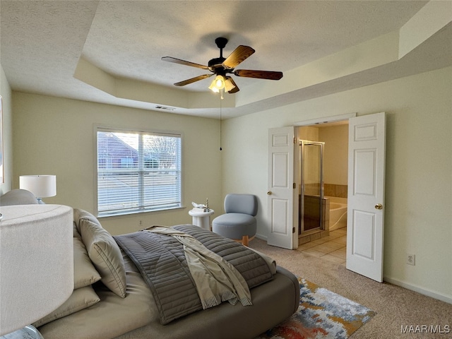 bedroom with light carpet, ensuite bathroom, ceiling fan, a raised ceiling, and a textured ceiling