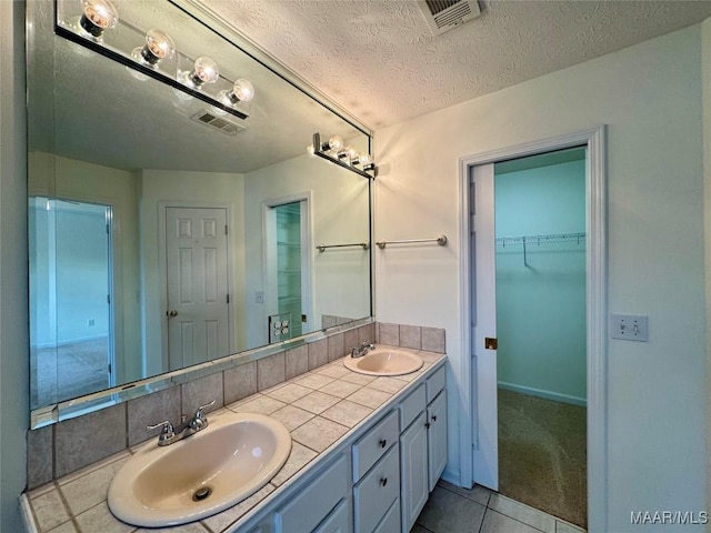 bathroom with vanity, tile patterned flooring, and a textured ceiling