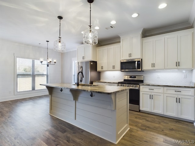 kitchen with pendant lighting, an island with sink, white cabinets, and appliances with stainless steel finishes