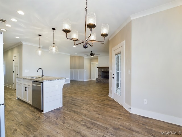 kitchen featuring stainless steel dishwasher, hanging light fixtures, sink, white cabinets, and a kitchen island with sink