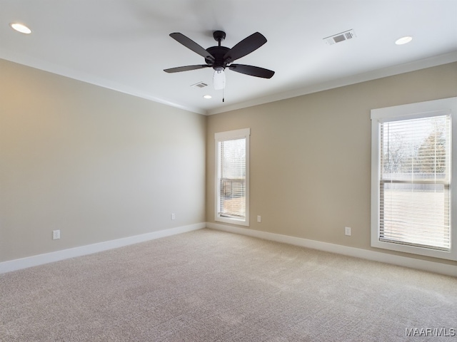 empty room with ceiling fan, light colored carpet, and crown molding