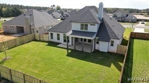 rear view of house with a patio area, a fenced backyard, and a lawn