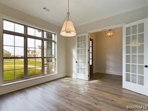 unfurnished dining area with baseboards and wood finished floors