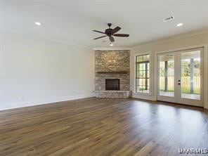 unfurnished living room with french doors, crown molding, a fireplace, wood finished floors, and baseboards