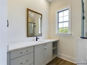 bathroom with wood finished floors, vanity, and baseboards