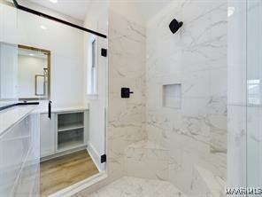 bathroom featuring a marble finish shower