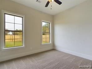 carpeted empty room with visible vents, baseboards, and a ceiling fan