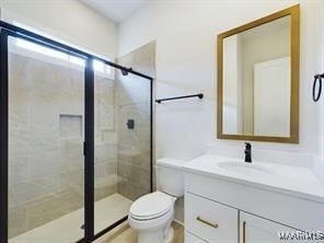 bathroom featuring toilet, a stall shower, and vanity