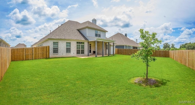 8319 Young Xing, Montgomery, AL 36116 - back of property featuring a fenced backyard, a patio, a chimney, and brick siding