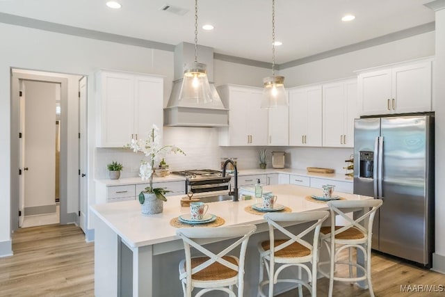 8319 Young Xing, Montgomery, AL 36116 - kitchen featuring stainless steel appliances, custom exhaust hood, light countertops, white cabinets, and decorative backsplash