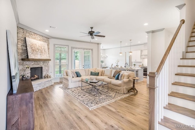 8319 Young Xing, Montgomery, AL 36116 - living room featuring a ceiling fan, stairs, light wood-style floors, a fireplace, and ornamental molding
