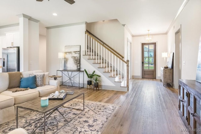 8319 Young Xing, Montgomery, AL 36116 - living room featuring stairs, wood finished floors, a chandelier, crown molding, and a ceiling fan