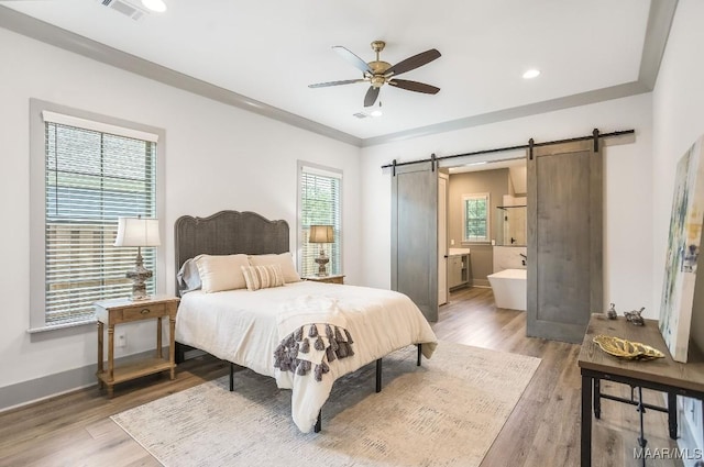8319 Young Xing, Montgomery, AL 36116 - bedroom with a barn door, light wood finished floors, ensuite bathroom, a ceiling fan, and recessed lighting