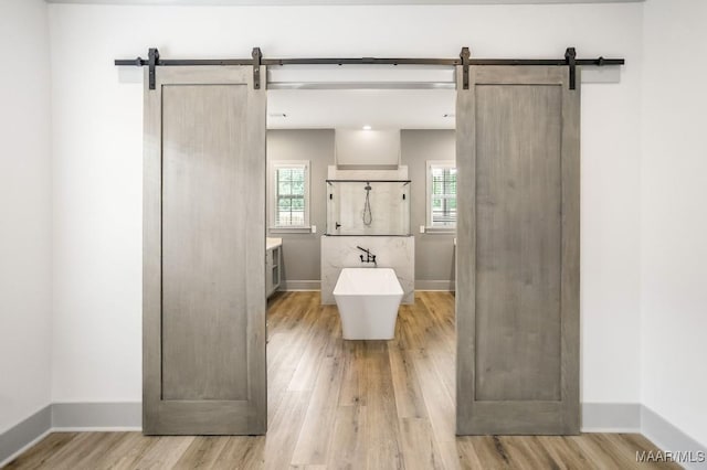 8319 Young Xing, Montgomery, AL 36116 - full bathroom featuring wood finished floors, a freestanding bath, vanity, and healthy amount of natural light