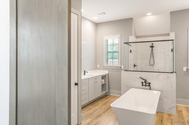 8319 Young Xing, Montgomery, AL 36116 - bathroom featuring a freestanding bath, a marble finish shower, vanity, wood finished floors, and recessed lighting