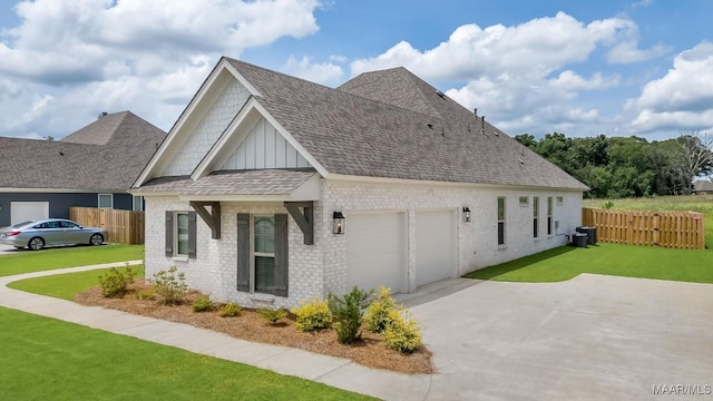 8319 Young Xing, Montgomery, AL 36116 - view of home's exterior featuring board and batten siding, brick siding, a shingled roof, driveway, and a garage