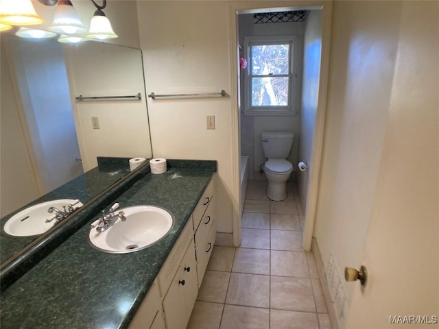 bathroom with toilet, tile patterned floors, and vanity