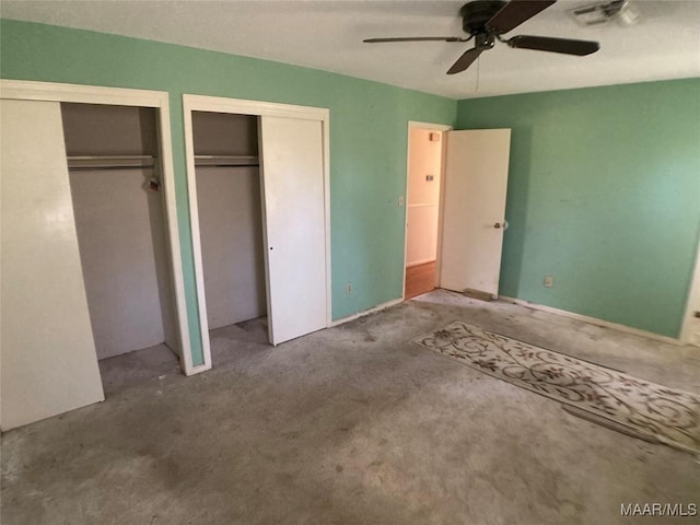 unfurnished bedroom featuring ceiling fan and multiple closets