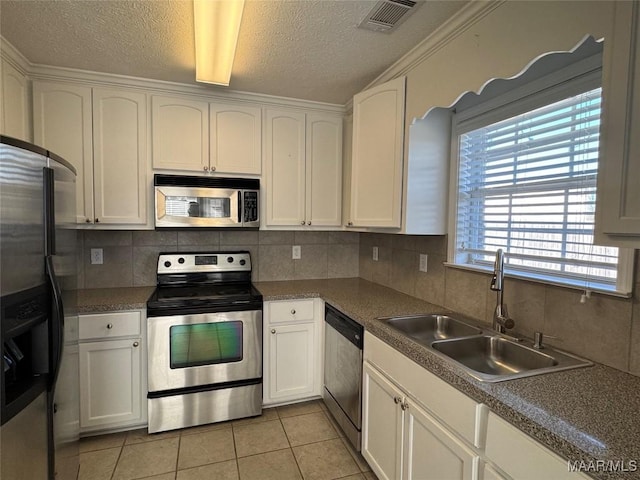 kitchen featuring light tile patterned floors, sink, white cabinetry, and appliances with stainless steel finishes