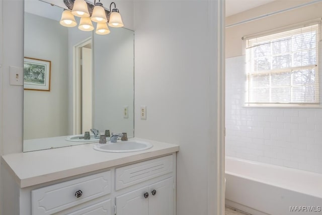 bathroom featuring vanity, a notable chandelier, and a bathing tub