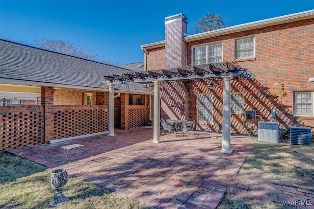 back of property featuring central AC unit, a pergola, and a patio