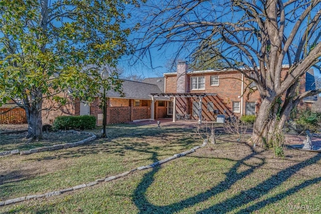 back of house featuring a lawn and a pergola