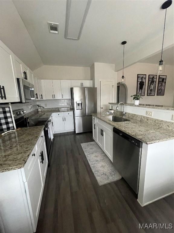 kitchen with stainless steel appliances, hanging light fixtures, light stone countertops, white cabinets, and sink