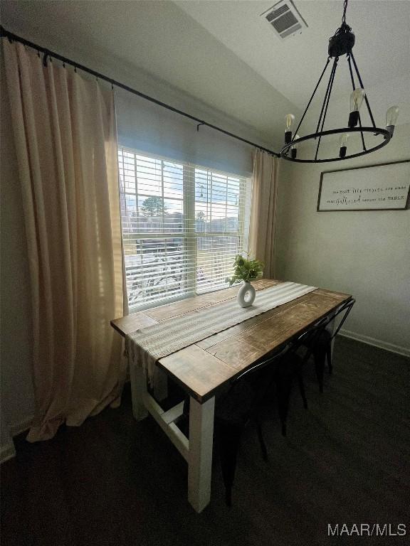 dining area with lofted ceiling and a notable chandelier