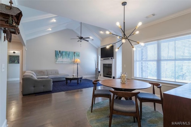 dining space with ornamental molding, lofted ceiling, ceiling fan with notable chandelier, and dark hardwood / wood-style flooring