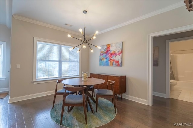 dining room with dark hardwood / wood-style floors, crown molding, and a chandelier