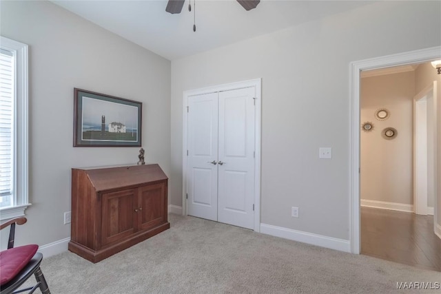 interior space featuring ceiling fan and light colored carpet