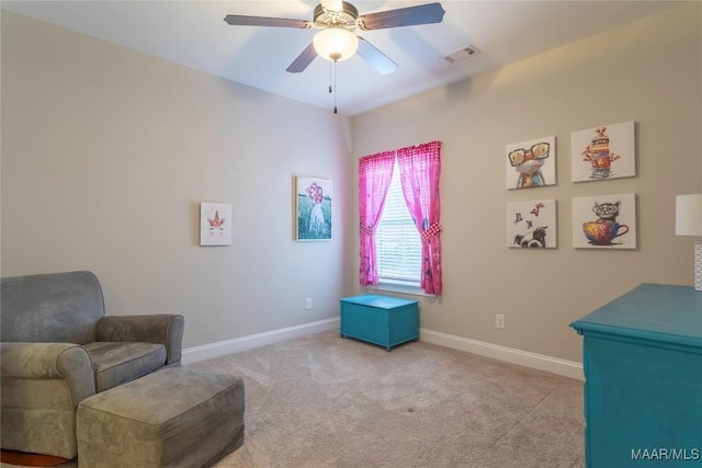 living area featuring light carpet and ceiling fan