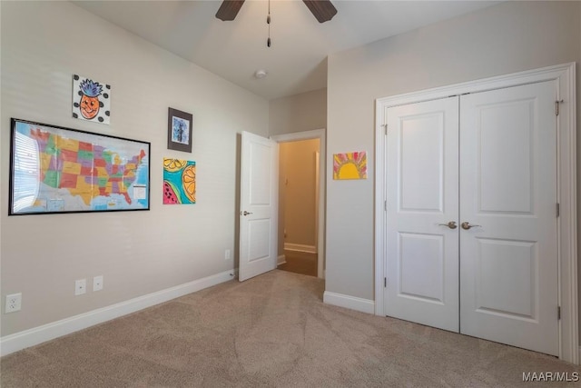 unfurnished bedroom featuring ceiling fan, light colored carpet, and a closet