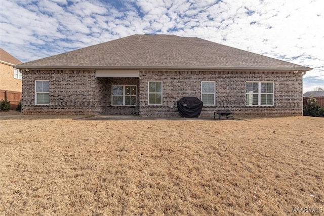 back of property with a yard and a patio