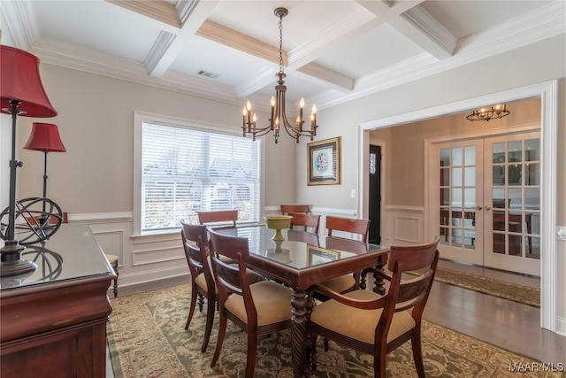 dining room featuring hardwood / wood-style floors, beamed ceiling, coffered ceiling, ornamental molding, and french doors