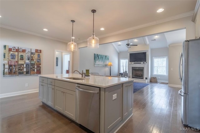 kitchen featuring vaulted ceiling, gray cabinets, sink, a kitchen island with sink, and stainless steel appliances