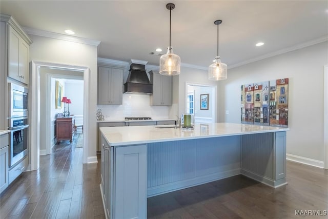 kitchen with decorative light fixtures, gray cabinets, appliances with stainless steel finishes, a large island, and custom range hood