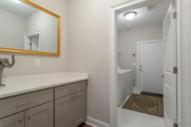 bathroom featuring vanity and washing machine and clothes dryer