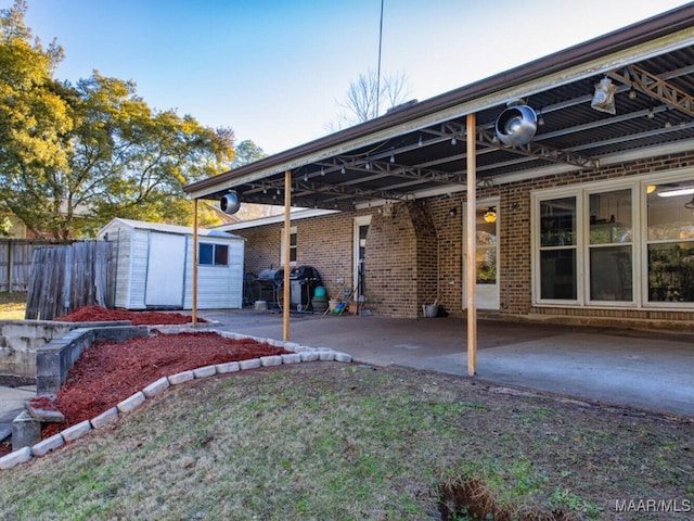 rear view of house featuring a storage shed and a patio