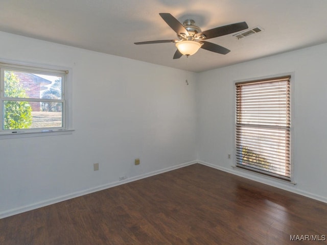 spare room with ceiling fan and dark hardwood / wood-style flooring