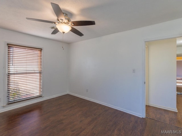 unfurnished room with ceiling fan and dark wood-type flooring