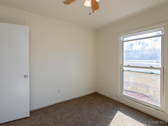 unfurnished room featuring ceiling fan, ornamental molding, and dark carpet