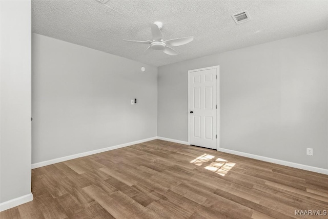 spare room with ceiling fan, a textured ceiling, and light hardwood / wood-style flooring