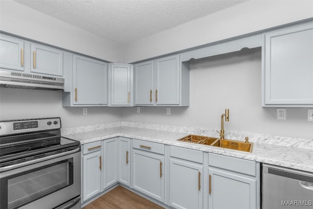 kitchen with sink, a textured ceiling, gray cabinetry, and stainless steel appliances