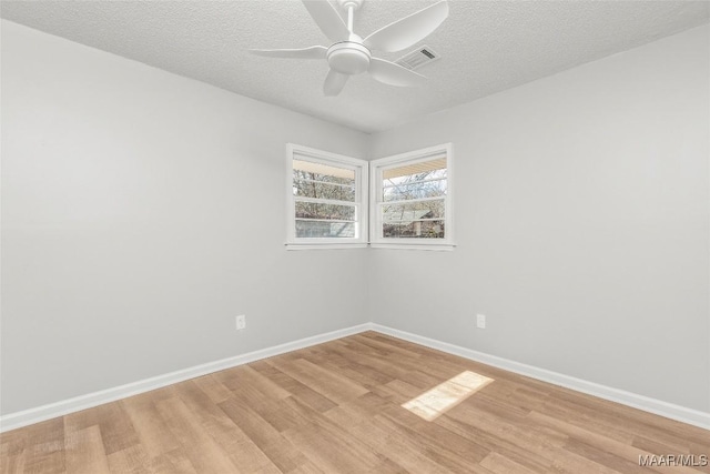 unfurnished room with ceiling fan, a textured ceiling, and light hardwood / wood-style flooring