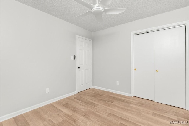 unfurnished bedroom featuring a textured ceiling, ceiling fan, and light wood-type flooring